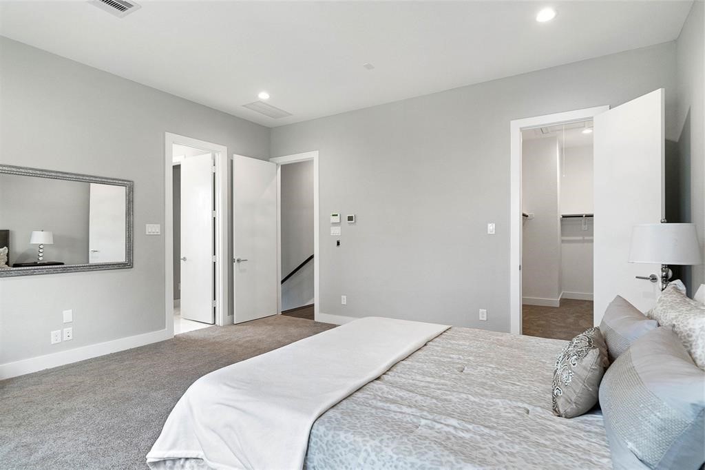 8411 Hempstead Road, Unit F Houston, TX 77008 - Photo 14 of 25 a bedroom with a large bed a chandelier and closet