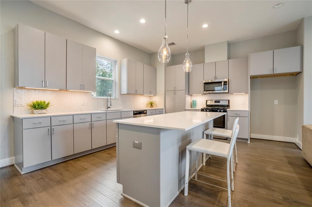 8411 Hempstead Road, Unit F Houston, TX 77008 - Photo 3 of 25 a kitchen with kitchen island granite countertop a sink a counter space appliances and cabinets