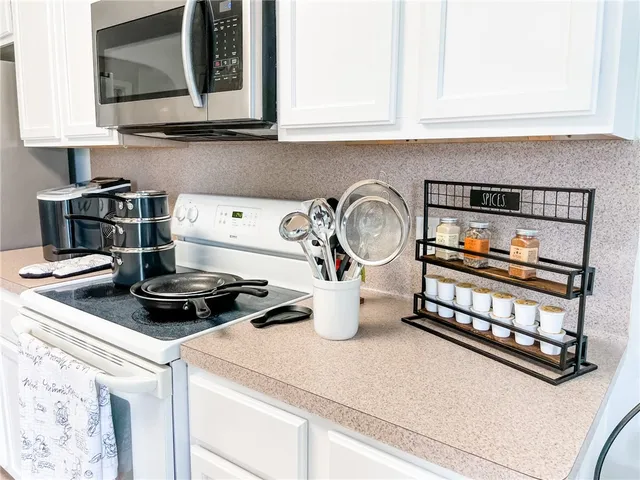 a kitchen with a stove and a white cabinets