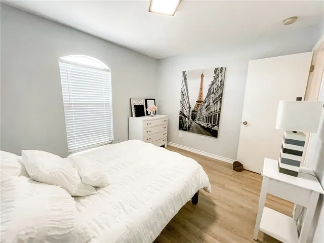 a bedroom with a large bed and a wooden floor