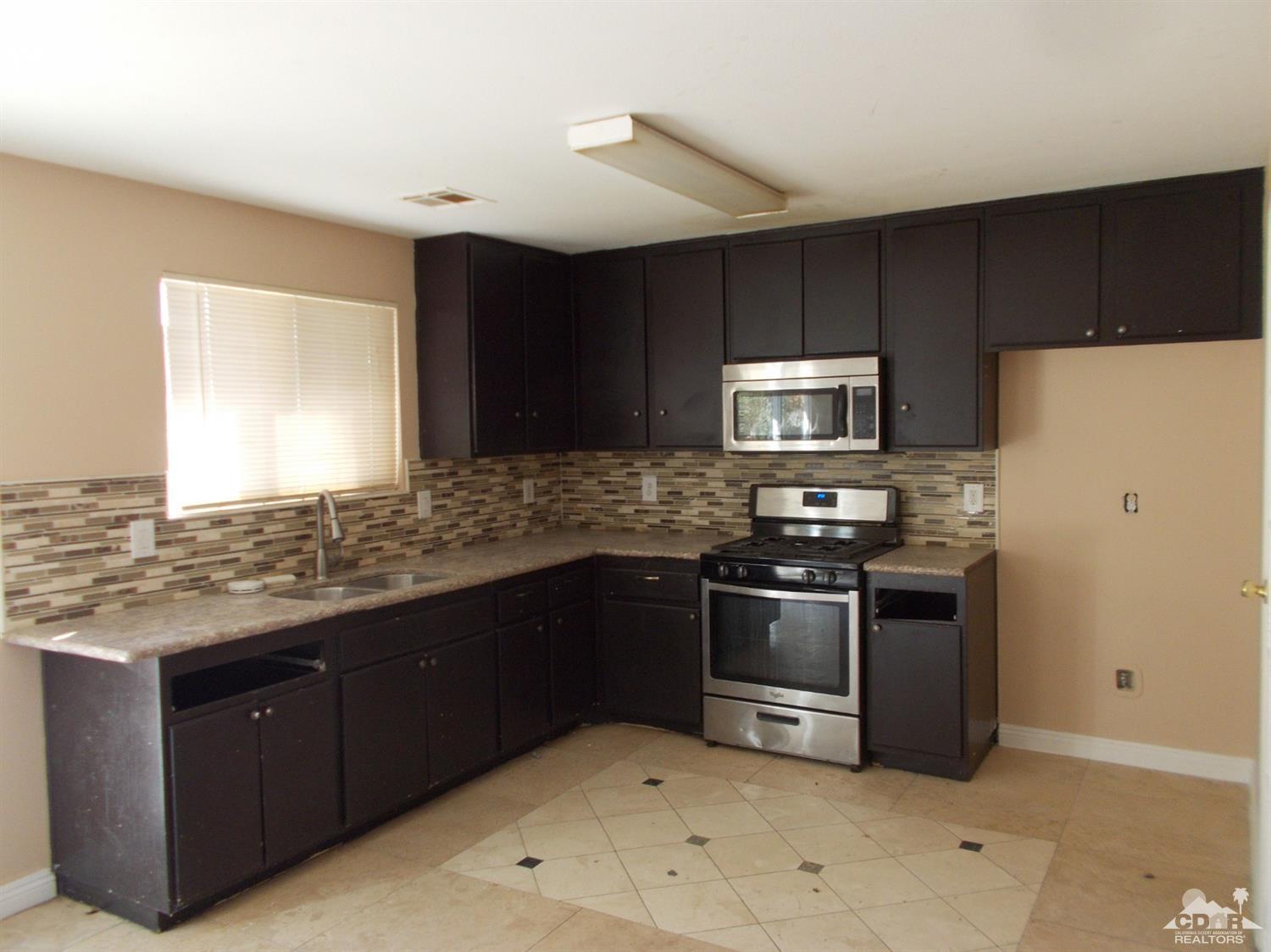 13080 Mountain View Road Desert Hot Springs, CA 92240 - Photo 2 of 11 a kitchen with stainless steel appliances granite countertop a refrigerator and a stove top oven