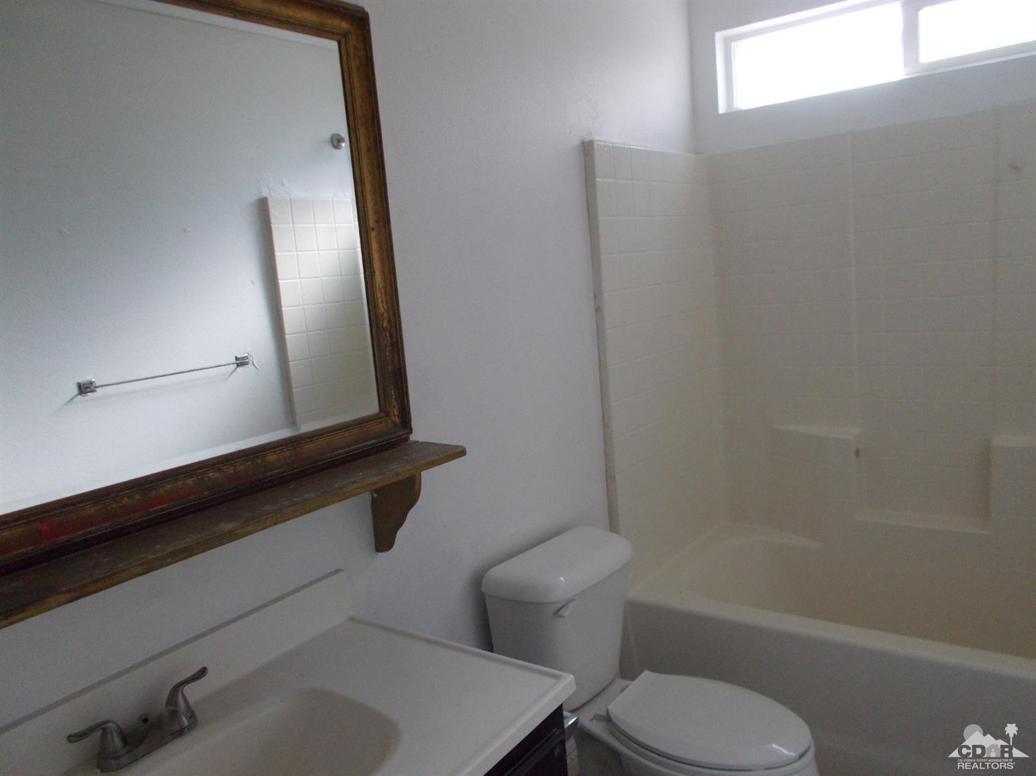 13080 Mountain View Road Desert Hot Springs, CA 92240 - Photo 8 of 11 a bathroom with a toilet sink and mirror