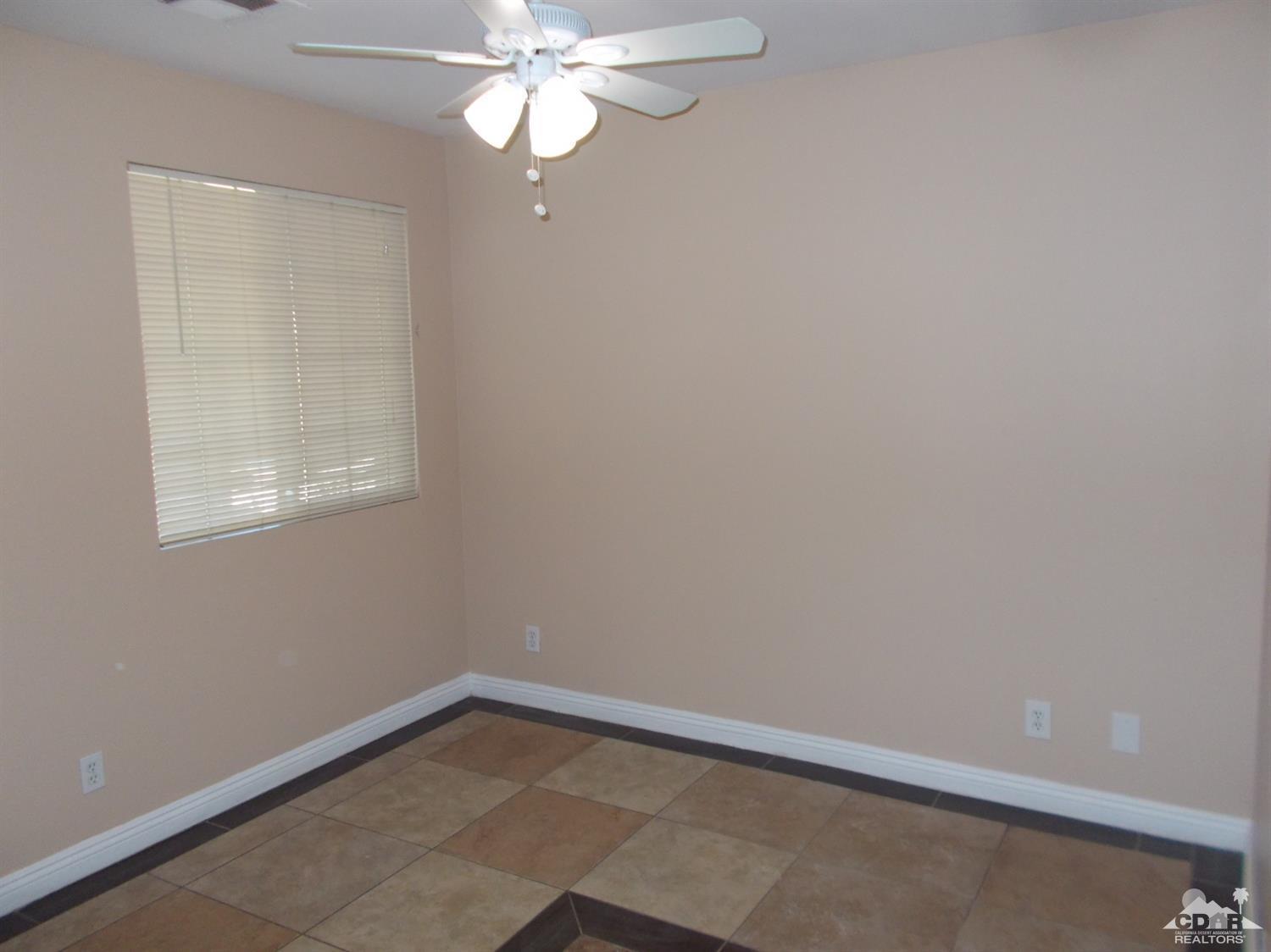 13080 Mountain View Road Desert Hot Springs, CA 92240 - Photo 9 of 11 an empty room with a window and chandelier fan