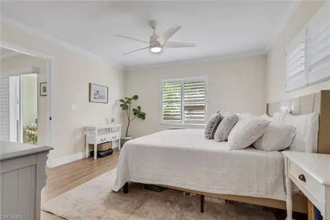 a bedroom with a bed a table and a potted plant