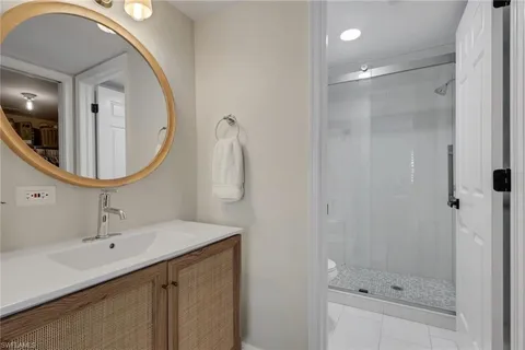 a bathroom with a sink a mirror a vanity and shower