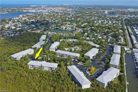 an aerial view of residential houses with outdoor space and trees