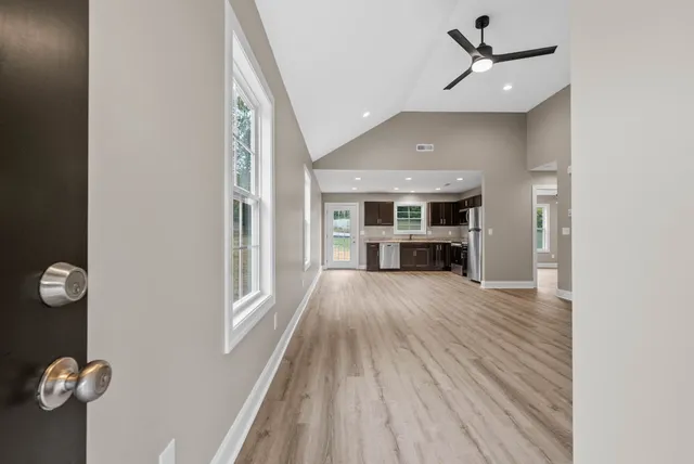 a view of empty room with wooden floor and window