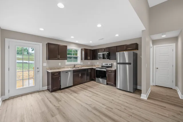 a kitchen with stainless steel appliances a refrigerator a sink a stove a microwave and cabinets