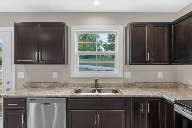 a kitchen with granite countertop a sink and a window
