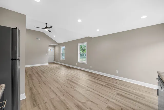 a view of empty room with wooden floor