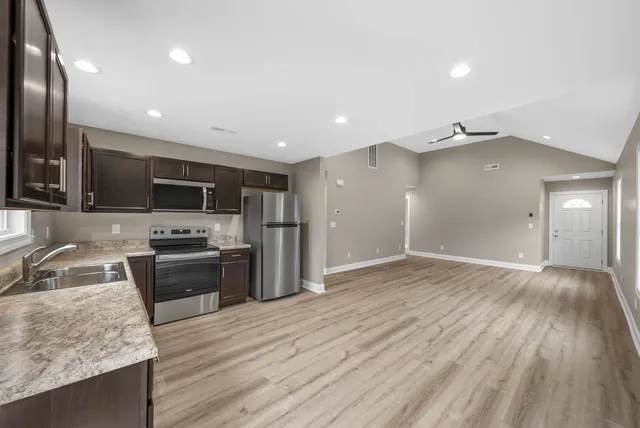 a kitchen with stainless steel appliances granite countertop a sink stove and refrigerator