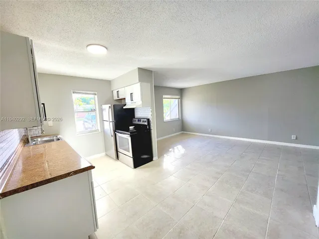a large kitchen with kitchen island a sink stainless steel appliances and cabinets