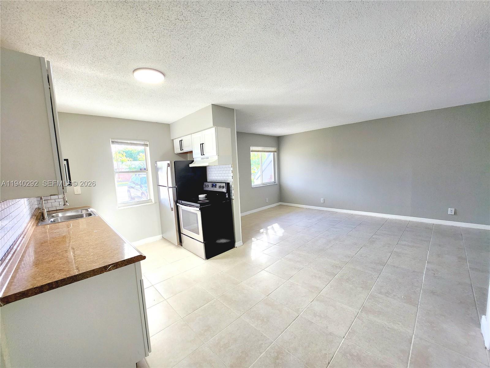 a large kitchen with kitchen island a sink stainless steel appliances and cabinets