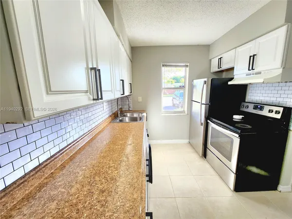 a view of a kitchen with wooden floor and a sink