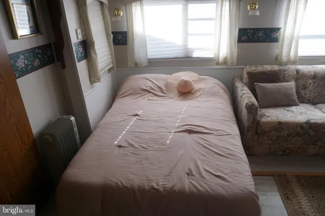 a bedroom with a large window and a couch