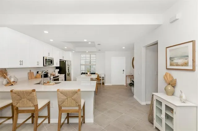 a living room with furniture flowerpot and a flat screen tv
