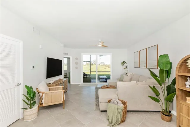 a living room with furniture and a floor to ceiling window