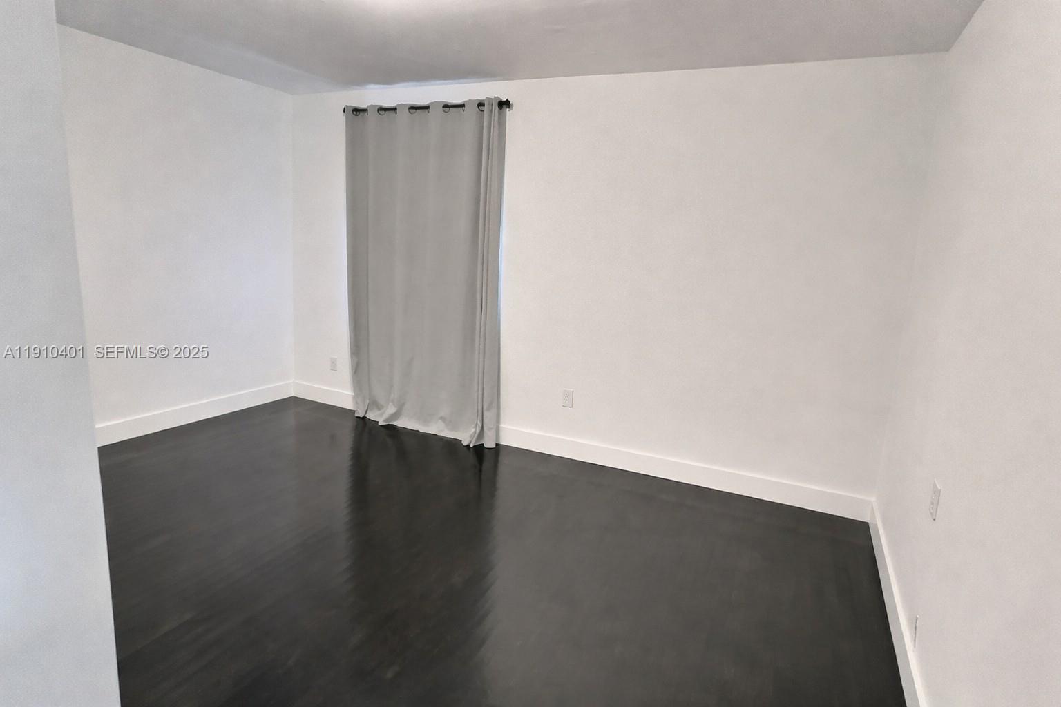 6541 Southwest 18th Street Miami, FL 33155 - Photo 11 of 22 an empty room with wooden floor and windows