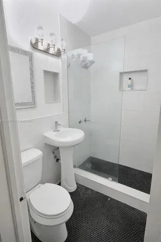 a bathroom with a sink toilet and shower