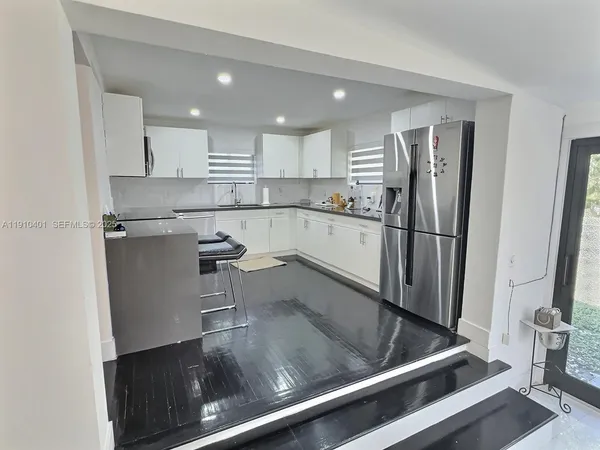 a kitchen with a refrigerator and a sink