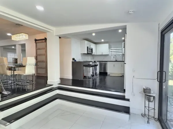 a kitchen with stainless steel appliances kitchen island granite countertop a refrigerator and cabinets