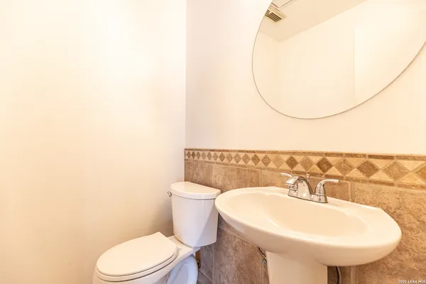 a bathroom with a sink a toilet and a mirror