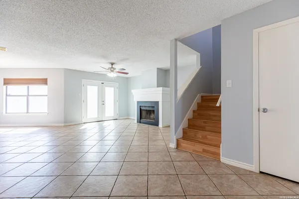 an empty room with a fireplace and windows