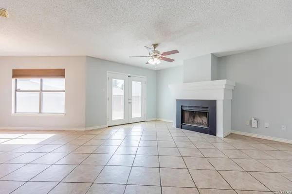 a view of an empty room with a fireplace and a window