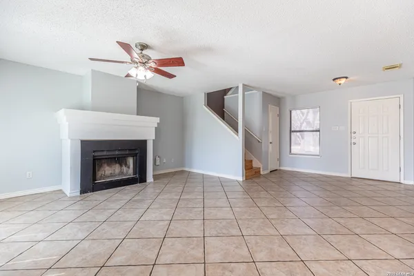 a view of an empty room with window and fireplace