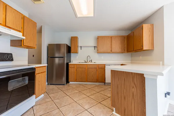 a kitchen with a refrigerator sink and cabinets