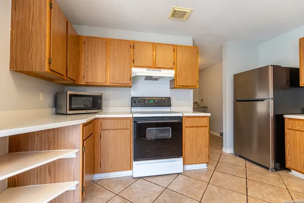 a kitchen with granite countertop a refrigerator stove and washer