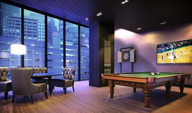 a room with furniture pool table wooden floor and windows
