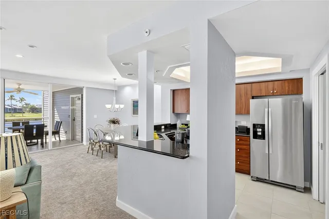 a living room with furniture a large window and stainless steel appliances