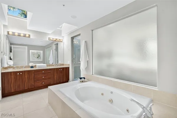 a spacious bathroom with a tub sink shower and mirror