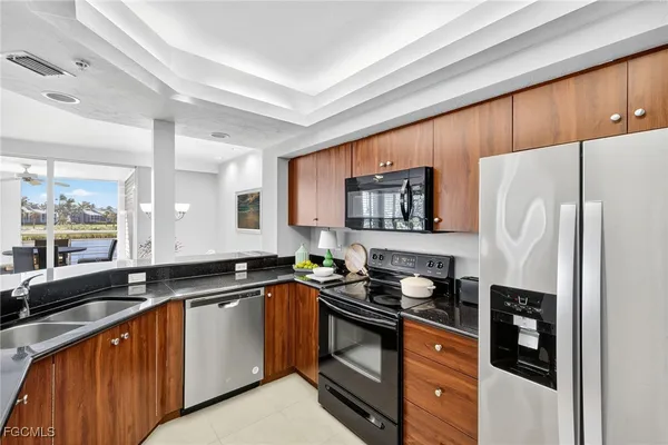 a kitchen with granite countertop a sink stove and refrigerator