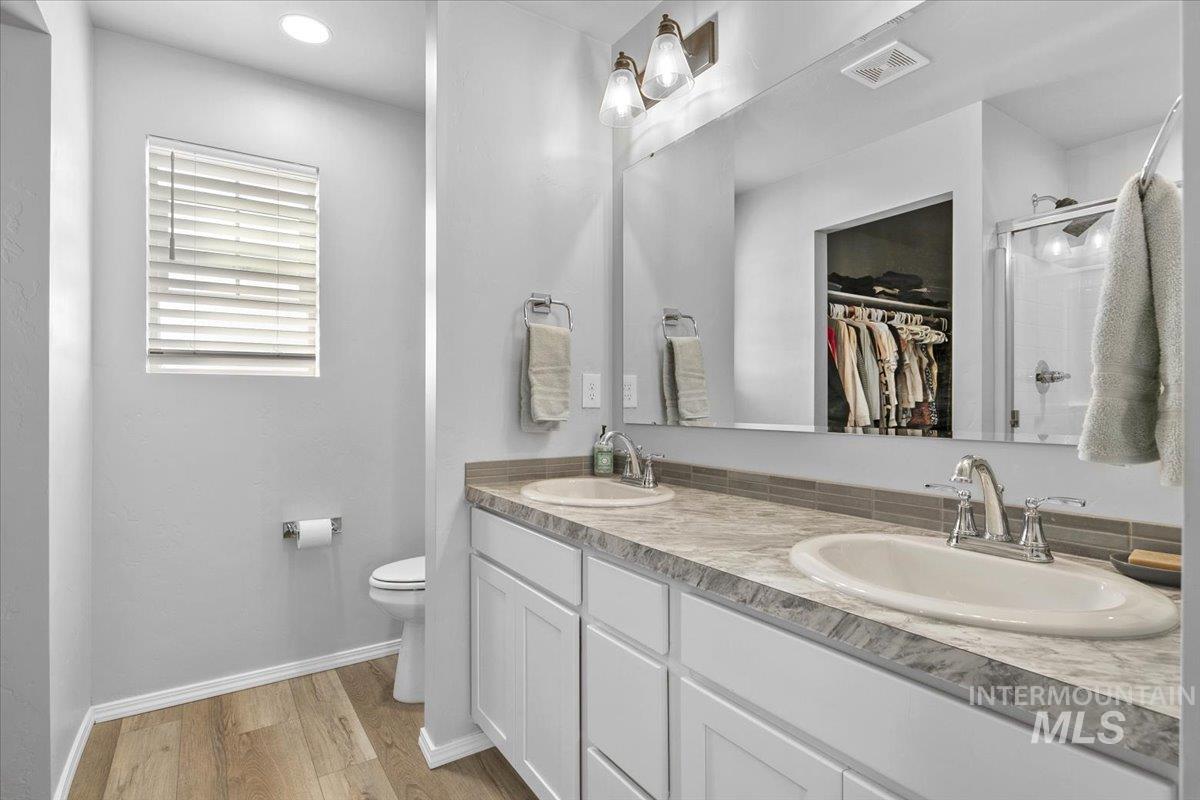 13520 Farwell Street Caldwell, ID 83607 - Photo 21 of 26 Bathroom featuring a shower stall, a spacious closet, double vanity, light wood-style floors, and recessed lighting