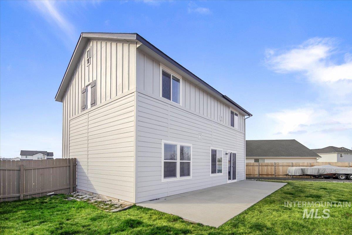 13520 Farwell Street Caldwell, ID 83607 - Photo 26 of 26 Back of property with board and batten siding, a patio area, and a fenced backyard