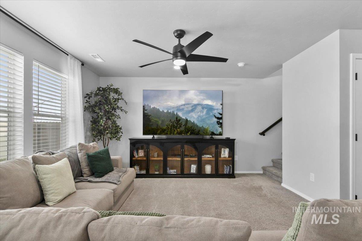 13520 Farwell Street Caldwell, ID 83607 - Photo 7 of 26 Carpeted living room featuring a ceiling fan and stairway