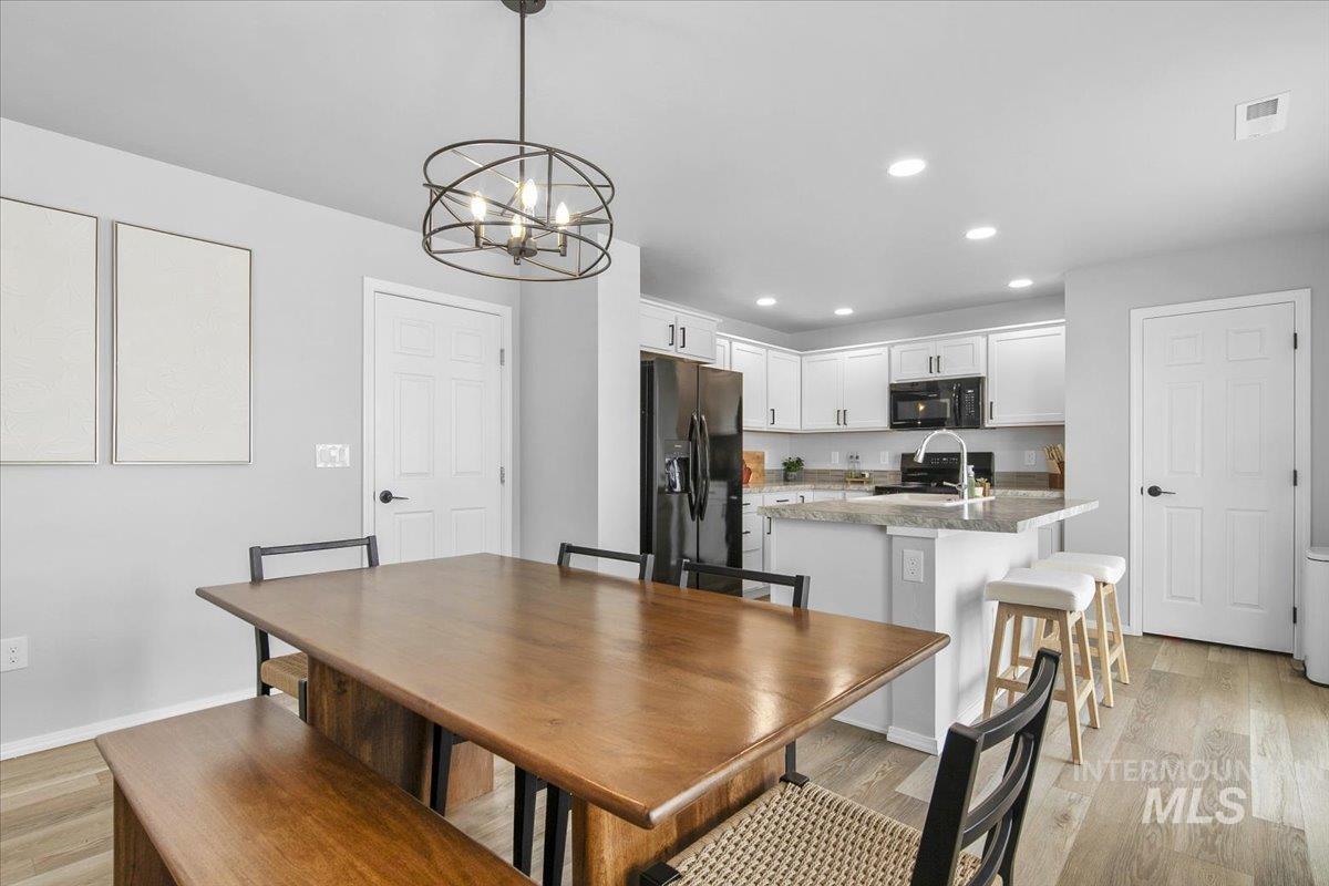 13520 Farwell Street Caldwell, ID 83607 - Photo 9 of 26 Dining area with light wood-style flooring and hanging lights