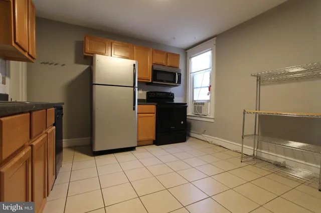 a kitchen with granite countertop a refrigerator and a stove top oven