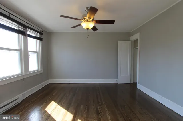 a view of wooden floor in an empty room with a window
