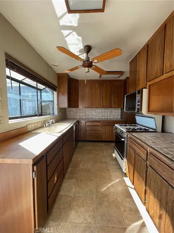 a kitchen with stainless steel appliances granite countertop a sink counter space cabinets and a large window