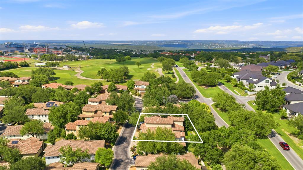15317 Falconhead Grove Loop Austin, TX 78738 - Photo 27 of 29 An aerial perspective reveals a vibrant neighborhood bordered by a verdant golf course and distant hills.