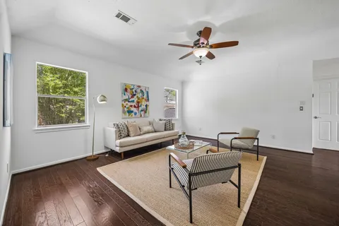 a living room with furniture and a wooden floor