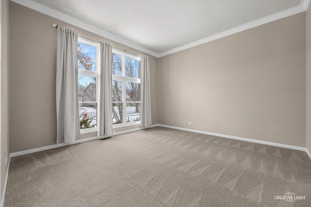 a view of an empty room with windows and closet