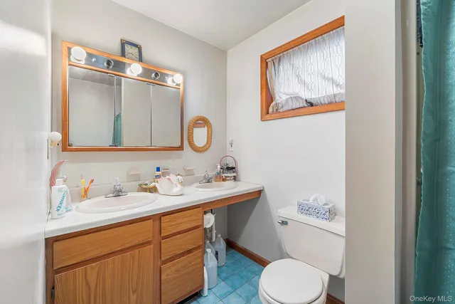 a bathroom with a toilet sink and mirror