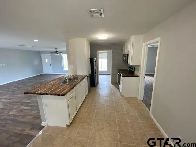 a large kitchen with a stove and white cabinets