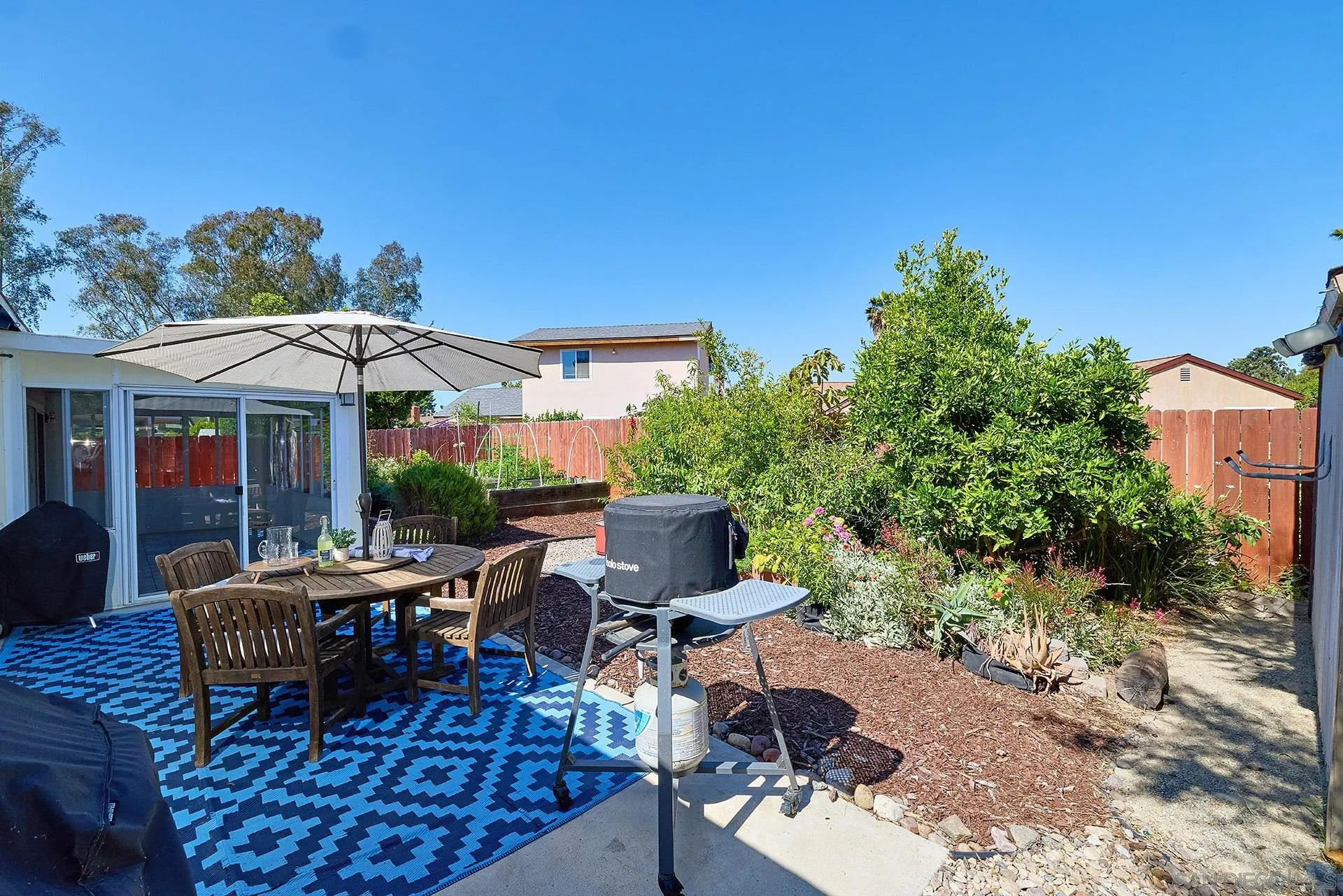 12835 Reo Real Drive Poway, CA 92064 - Photo 16 of 46 a view of a patio with a table and chairs under an umbrella