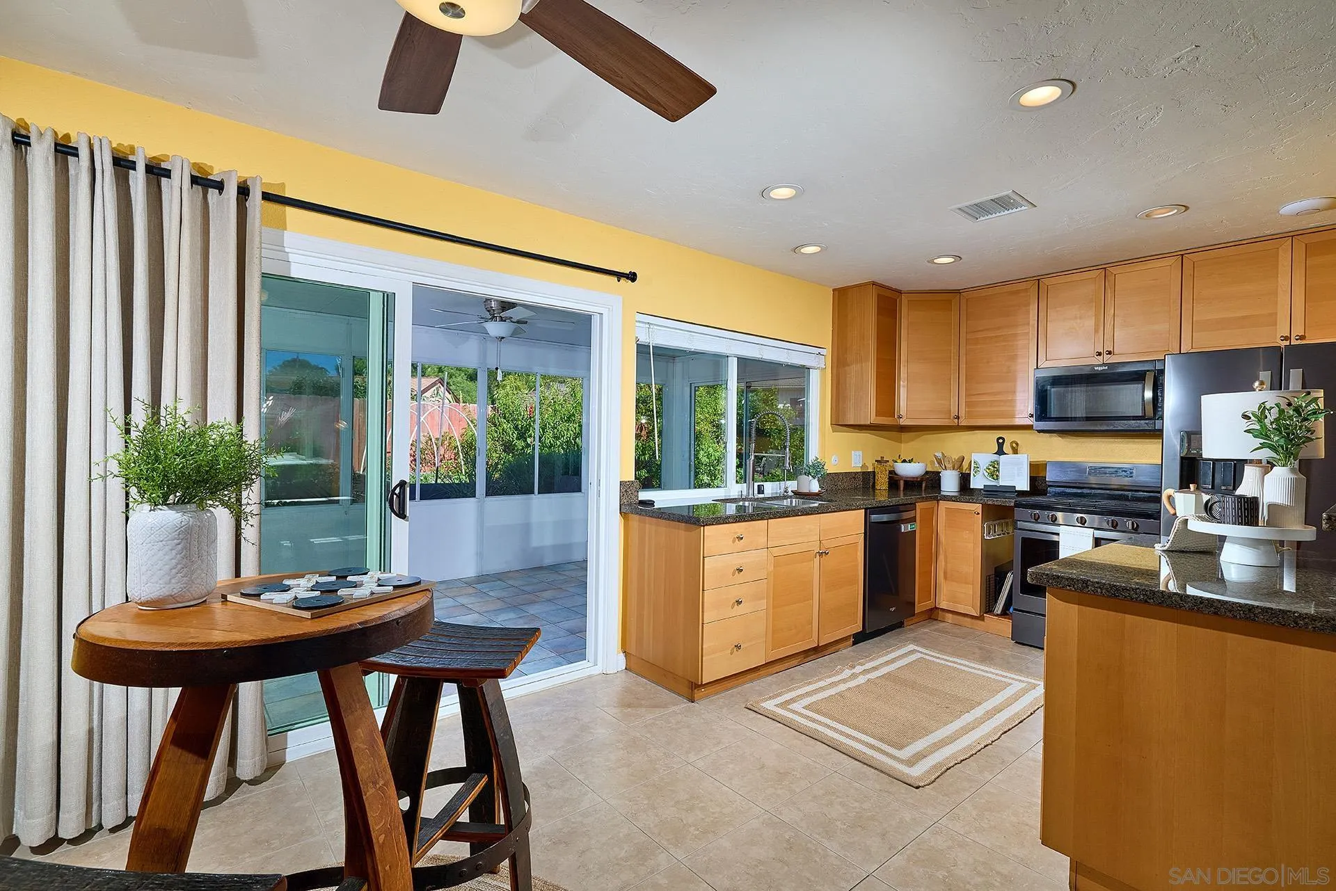 12835 Reo Real Drive Poway, CA 92064 - Photo 10 of 46 a kitchen with stainless steel appliances kitchen island granite countertop a table chairs sink and cabinets