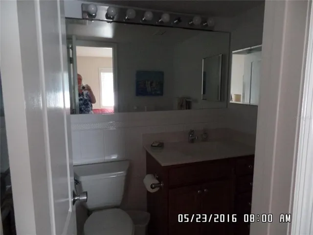 a bathroom with a sink a toilet and mirror